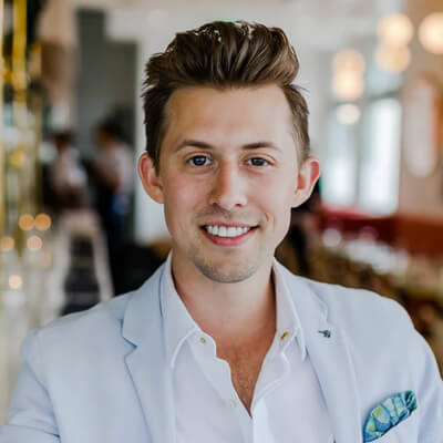 A boy sitting in a white shirt and a slight smile on his face
